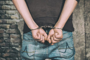 man-arrested-and-handcuffed-suspect-against-wall